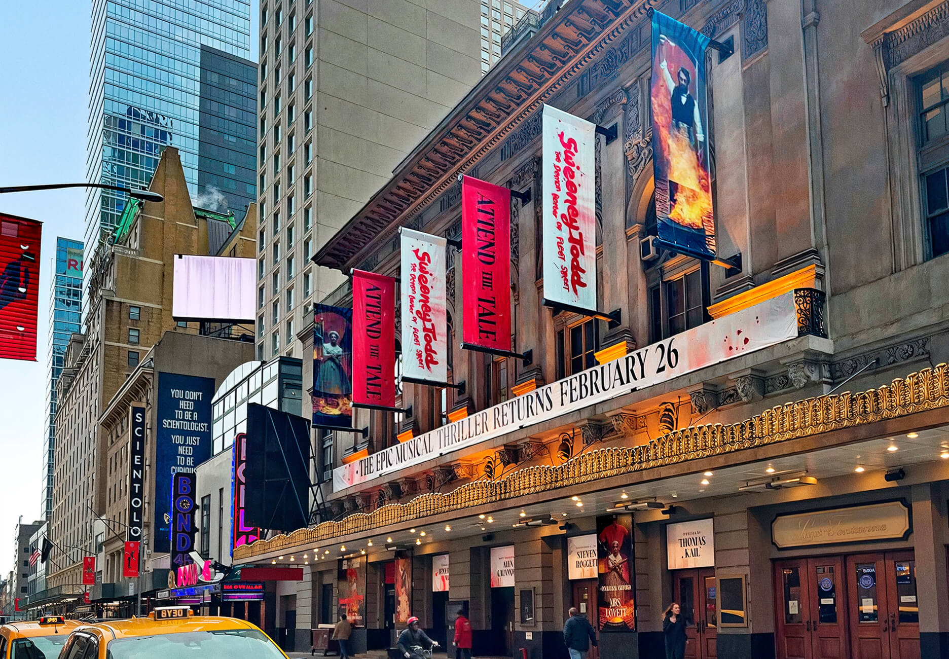 Façade de théâtre à Broadway ornée de bannières colorées pour promouvoir le spectacle Sweeney Todd.