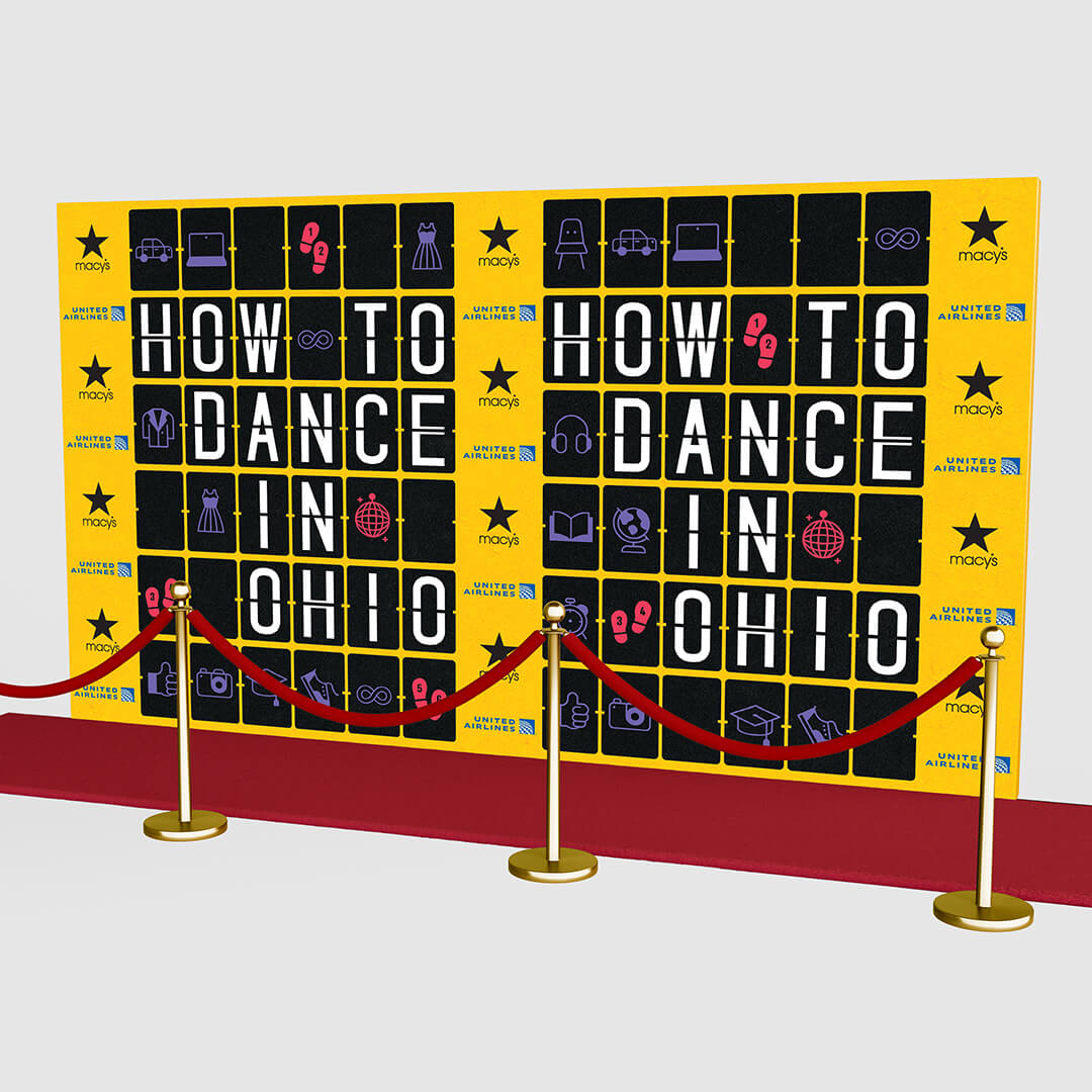Mur promotionnel pour la comédie musicale How to Dance in Ohio, décoré d’un tapis rouge.