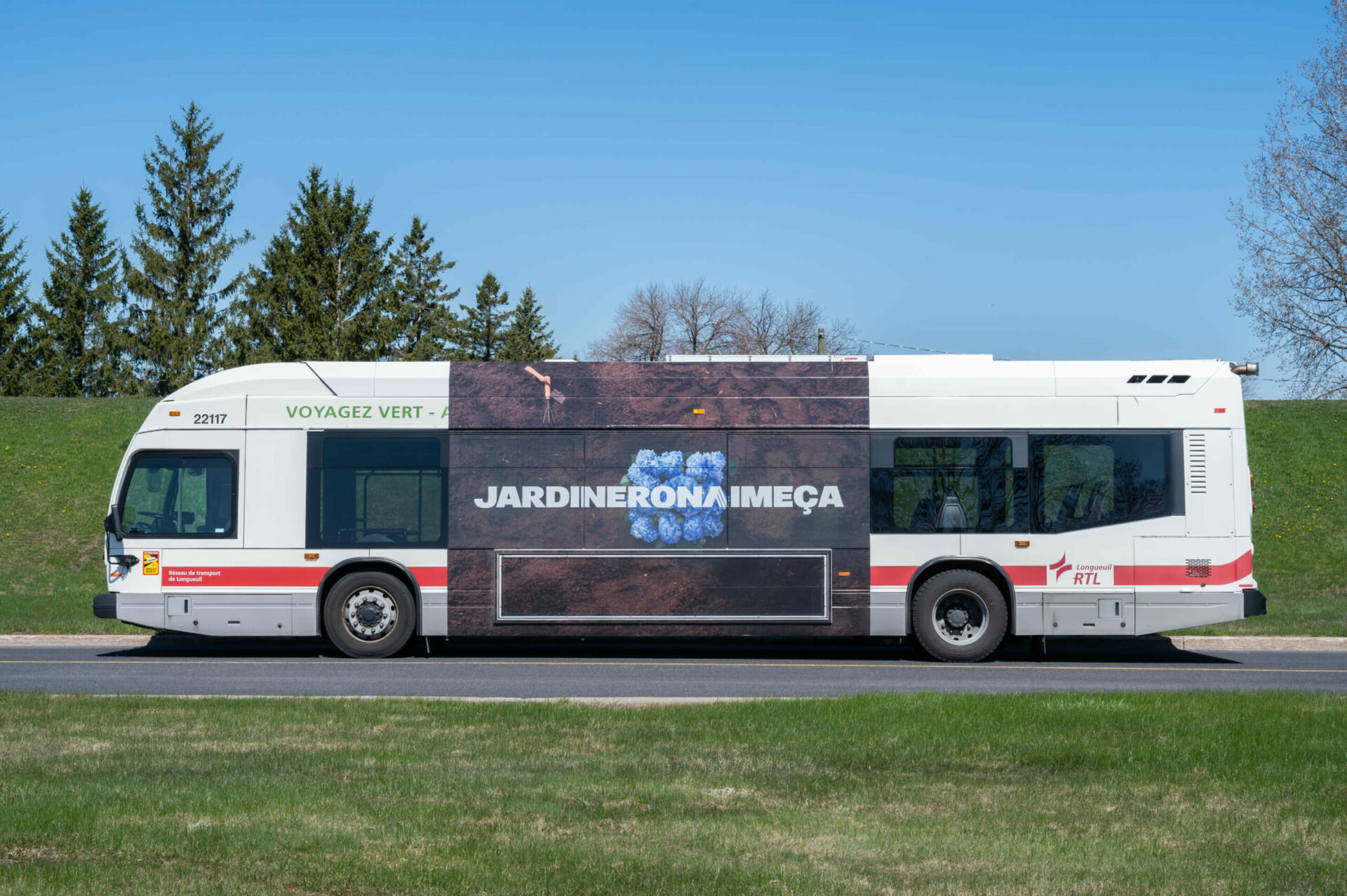 Publicité RONA POUR LA campagne de printemps affichée sur un autobus, avec le slogan «JARDINERONAIMEÇA ».