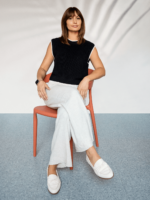 Chloé Lorini sitting in an orange chair smiling.