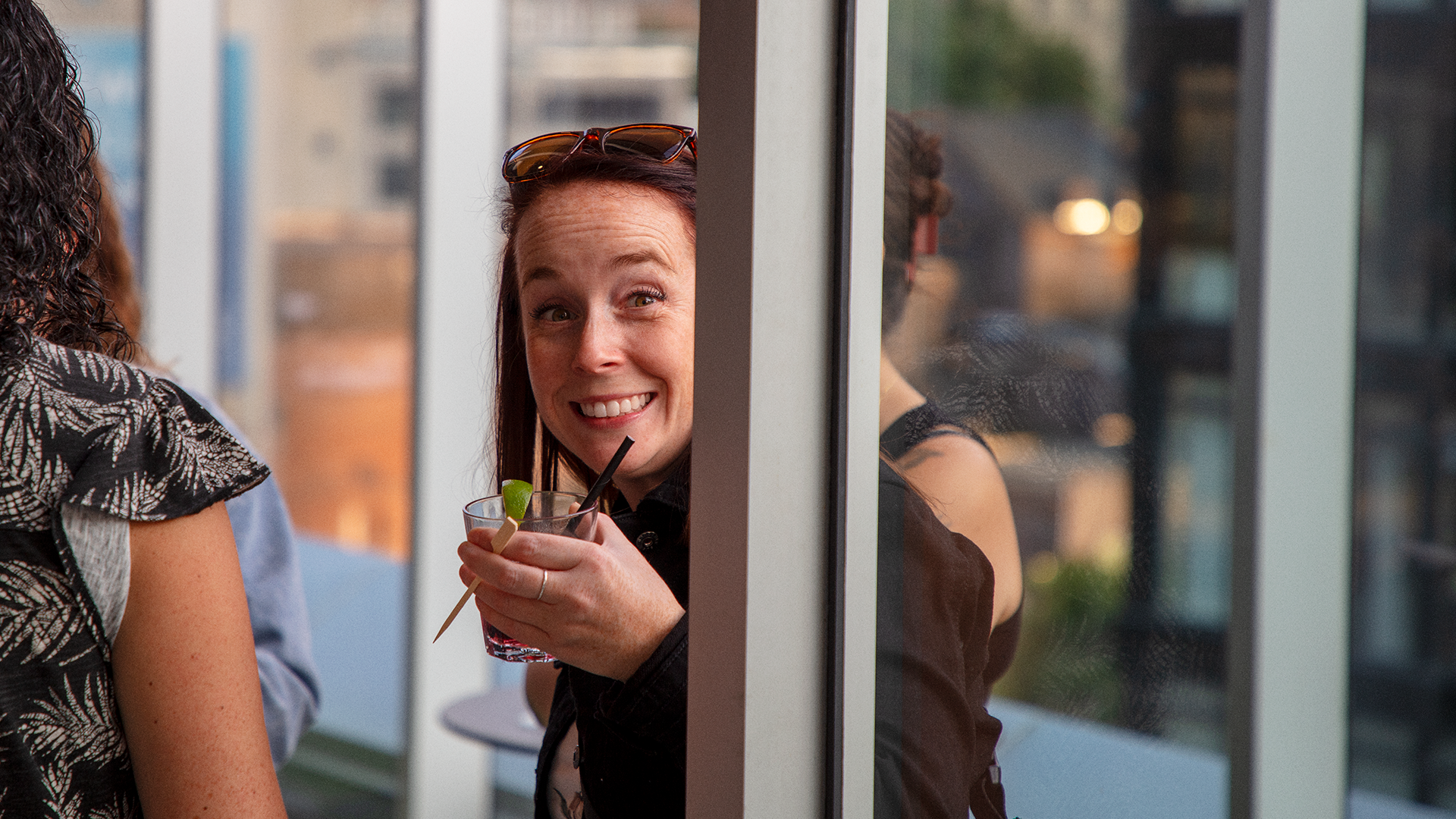 Smiling woman looking at the camera while holding a drink