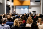 Photo of the McKinsey presentation at the C-Suite Marketing Summit with two speakers, Eric Falardeau and Oren Eizenman, addressing the audience.